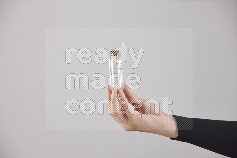 امرأة ترتدي عباءة سوداء تحمل أدوات زجاجية مختلفة في أوضاع متعددة