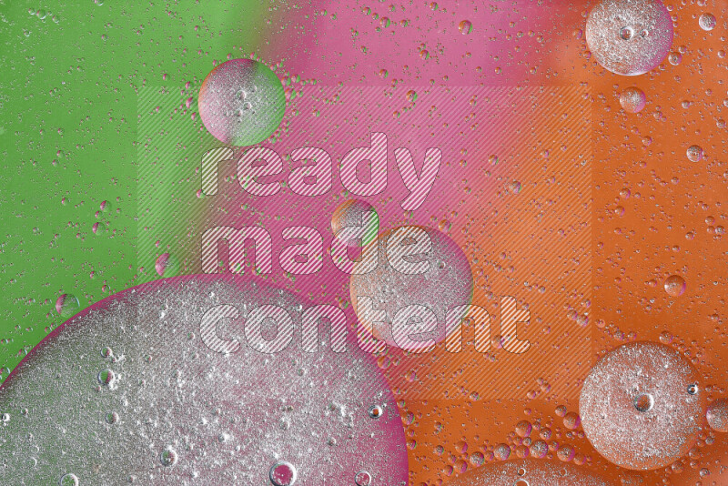 Close-ups of abstract oil bubbles on water surface in shades of orange, green and pink