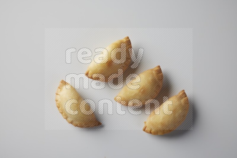 Four fried sambosa from a top angle on a white background