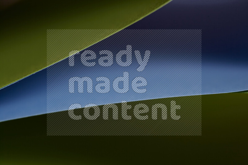 An abstract art showing blue and green paper sheets arranged in an overlapping curves