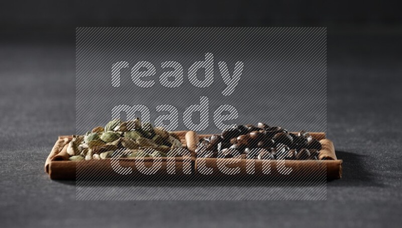 2 squares of cinnamon sticks full of coffee beans and cardamom on black flooring