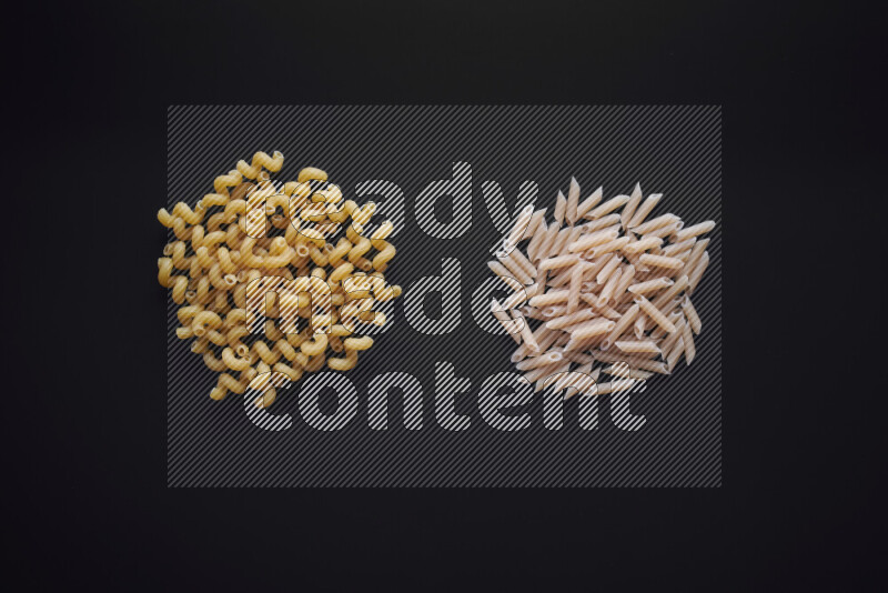 Different pasta types in bunches on black background