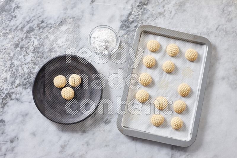 Kahk step by step with its ingredients ghee, sugar, flour, sesame, yeast, water and kahk flavor on grey marble background