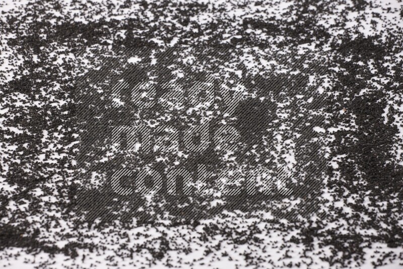 Black seeds spread on a white flooring