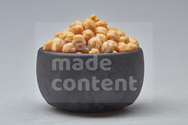 Close up shot of boiled chickpeas in a container on white background