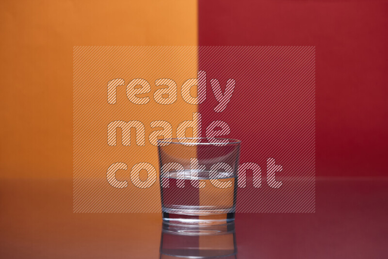 The image features a clear glassware filled with water, set against orange and red background