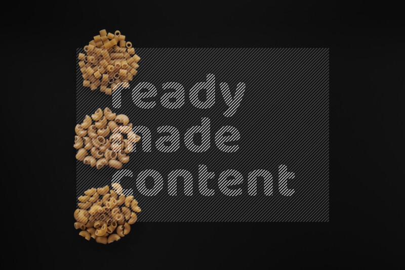 Different pasta types in 3 bunches on black background