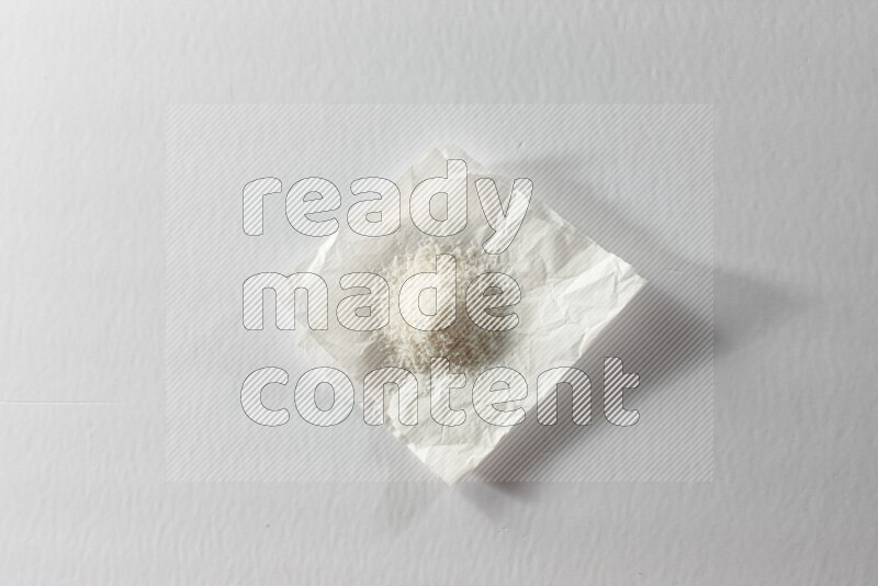 Desiccated coconut on a piece of paper on a white background in different angles