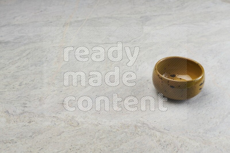 A multicolored pottery bowl on grey marble background