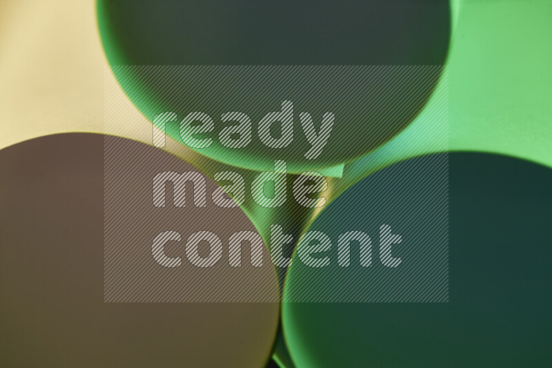The image shows an abstract paper art with circular shapes in varying shades of green and warm tones