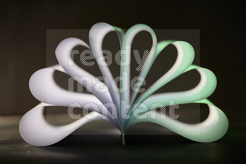 An abstract art piece displaying smooth curves in green and white gradients created by colored light
