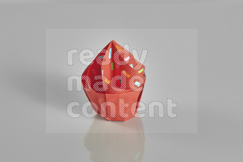 Origami cupcake on grey background