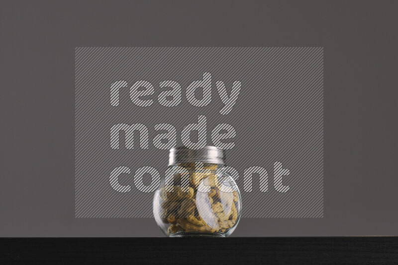 Turmeric in a glass jar on black background
