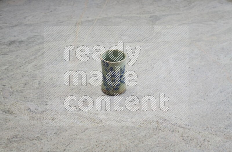 A multicolored pottery Cup on grey marble background