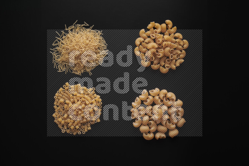 Different pasta types in bunches on black background