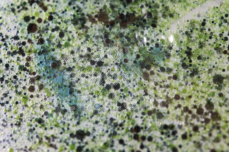 Close-ups of abstract green and blue watercolor drops on oil Surface on white background