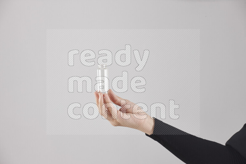 امرأة ترتدي عباءة سوداء تحمل أدوات زجاجية مختلفة في أوضاع متعددة