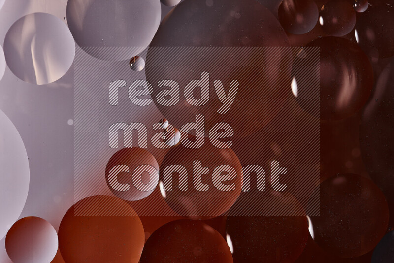 لقطات مقربة لفقاعات من الزيت على سطح الماء باللون الأسود والبرتقالي