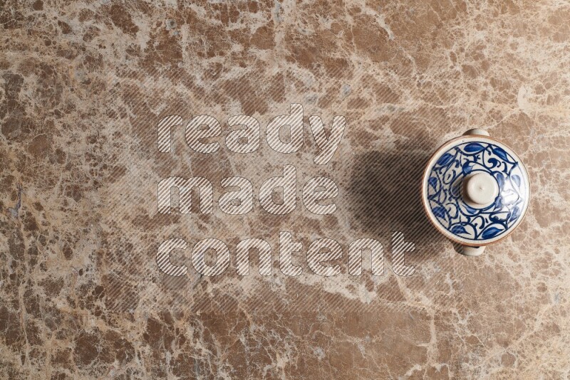 A multicolored pottery pot on beige marble background
