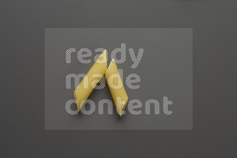 Penne pasta on grey background