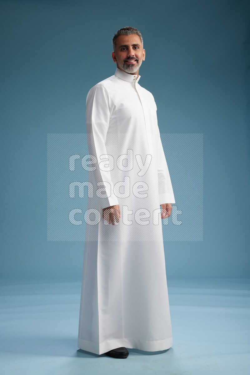 Saudi man waring thob posing to the camera on blue background