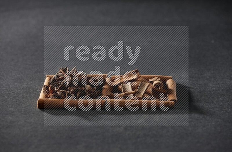 2 squares of cinnamon sticks full of star anise and cinnamon on black flooring