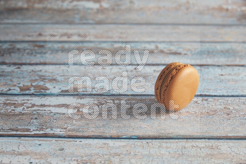 45º Shot of Brown Maple Taffy macaron on light blue wooden background