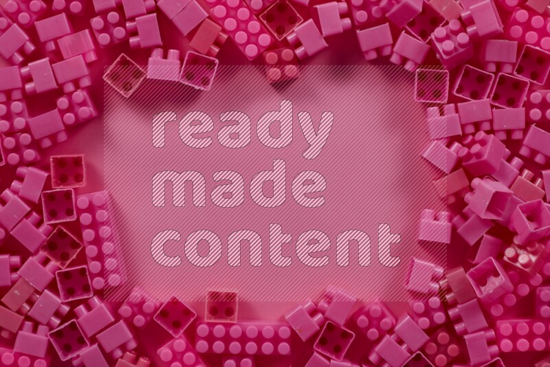 Pink plastic building blocks on pink background (kids toys)