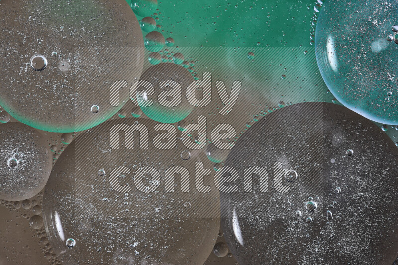 Close-ups of abstract oil bubbles on water surface in shades of green and brown