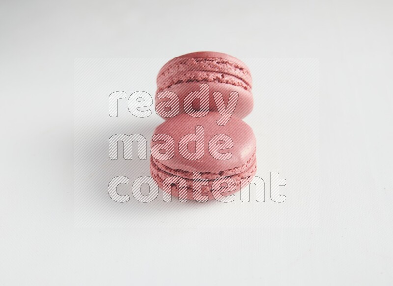 45º Shot of two Pink Raspberry macarons on white background