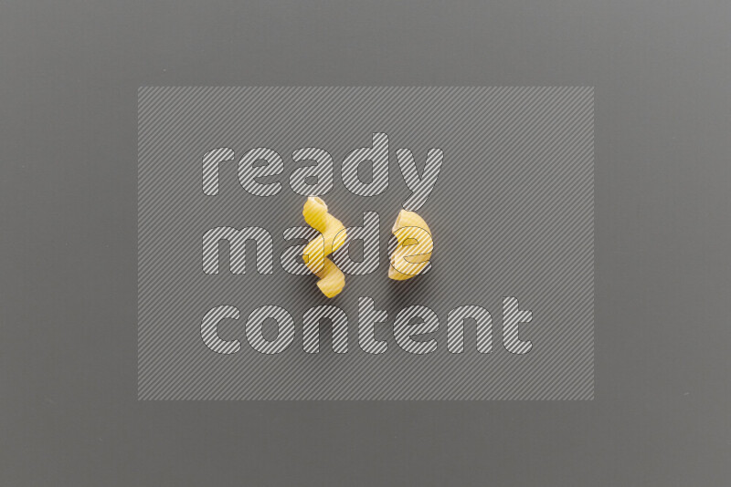 Twist pasta with other types of pasta on grey background