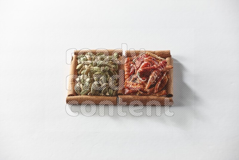 2 squares of cinnamon sticks full of cardamom and dried red chilis on white flooring