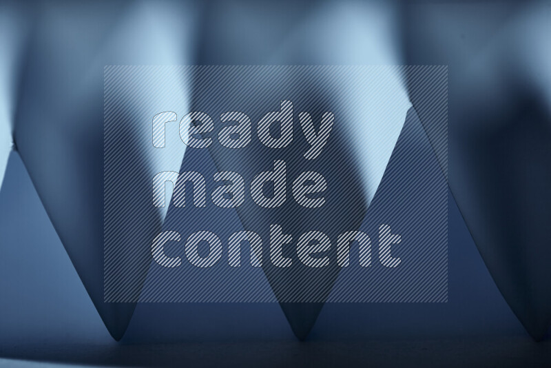 A close-up abstract image showing sharp geometric paper folds in blue gradients