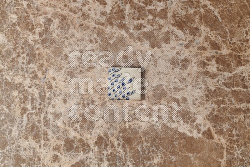 A decorative coaster on beige marble background