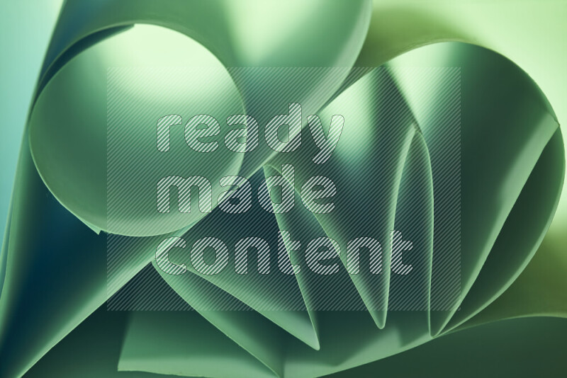 An artistic display of paper folds creating a harmonious blend of geometric shapes, highlighted by soft lighting in green tones