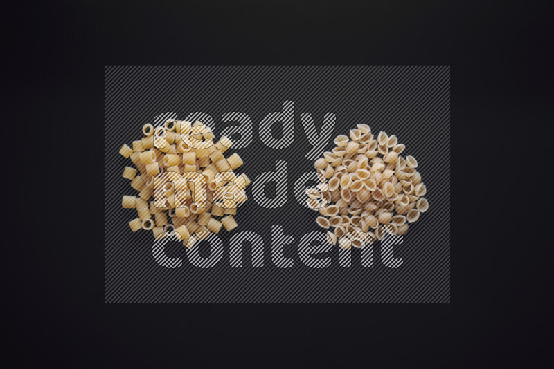 Different pasta types in bunches on black background