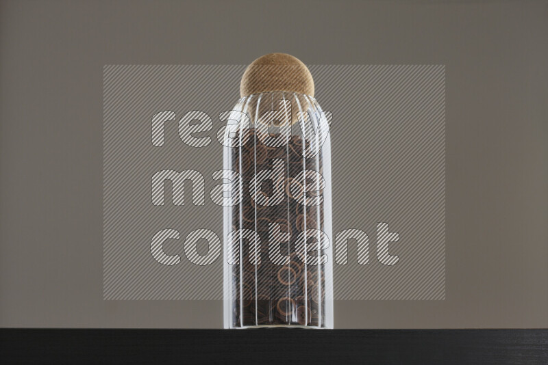 أزرار متنوعة في وعاء زجاجي علي خلفية سوداء