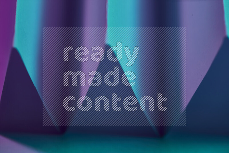 A close-up abstract image showing sharp geometric paper folds in blue and purple gradients