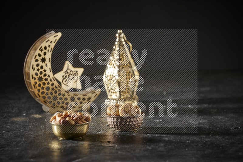 Nuts in a metal bowl with dried figs beside golden lanterns in a dark setup