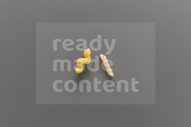 Twist pasta with other types of pasta on grey background