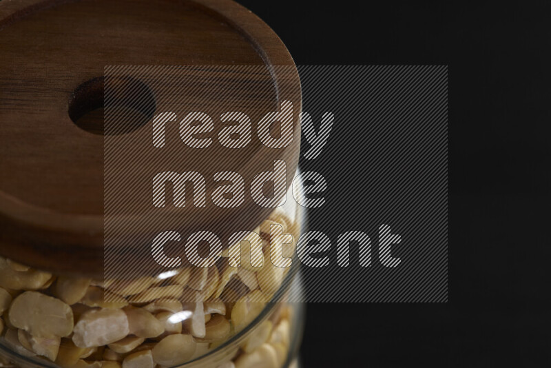 Crushed beans in a glass jar on black background