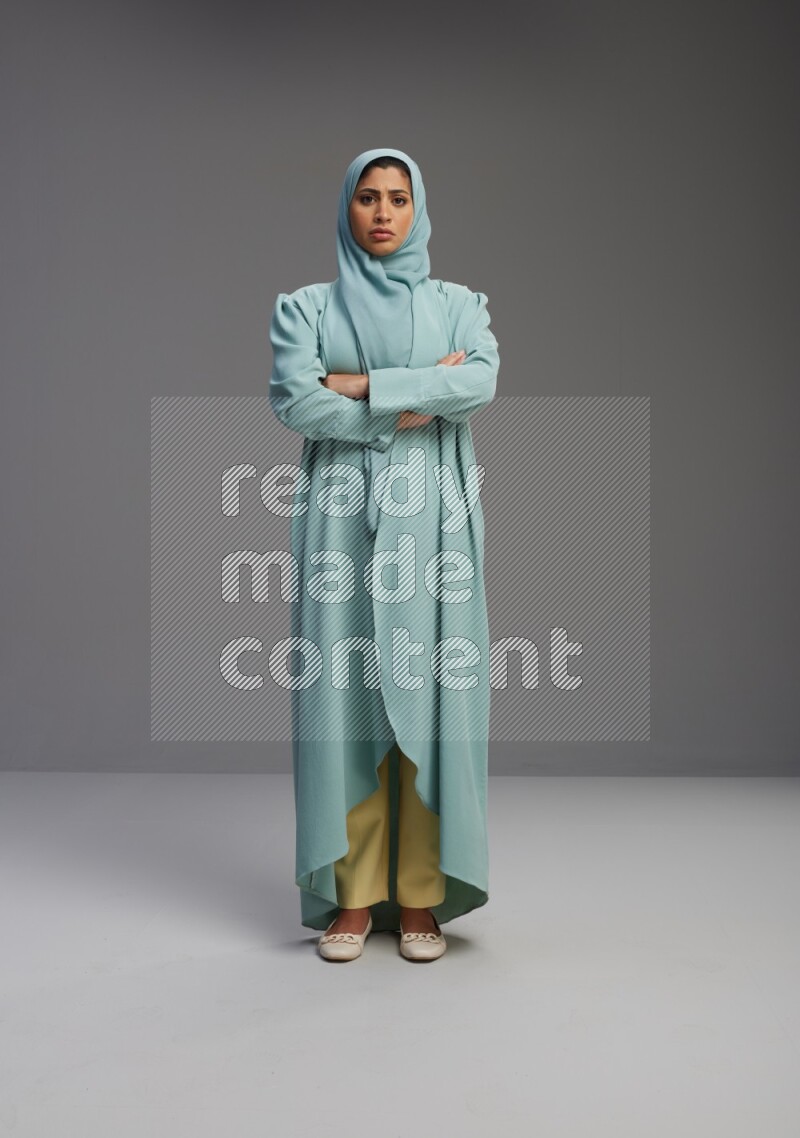Saudi Woman wearing Abaya standing with crossed arms on Gray background