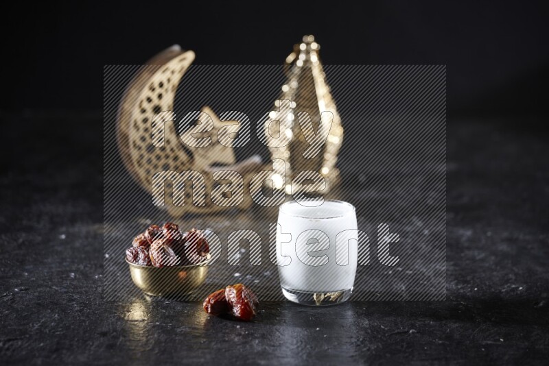 تمر في وعاء معدني مع مشروب السوبيا بجانب فوانيس ذهبية علي خلفية سوداء