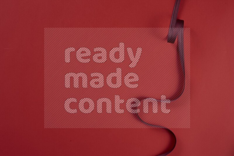 مجموعة من أدوات الخياطة والتفصيل حمراء اللون على خلفية حمراء