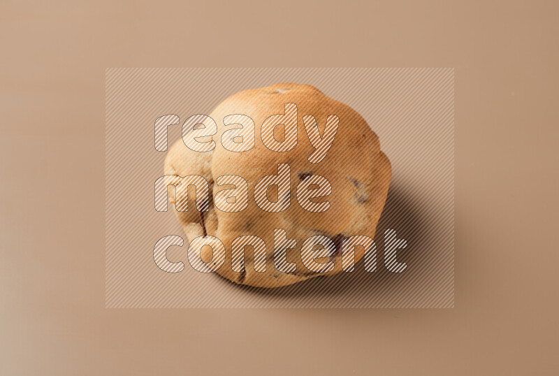 a whole chocolate chip cookie on a brown background