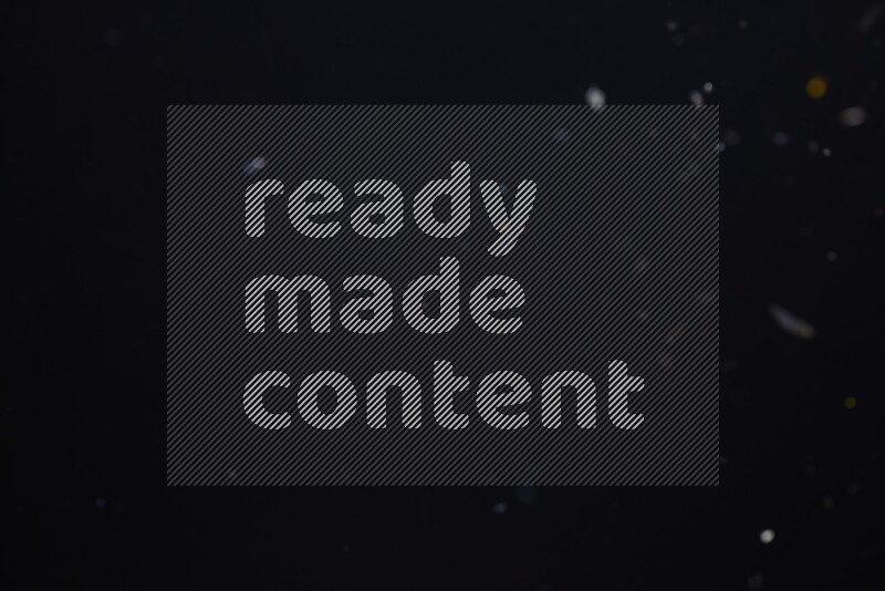 Falling multicolored confetti on black background