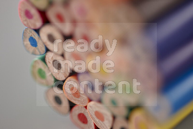 An array of colored pencils on grey background