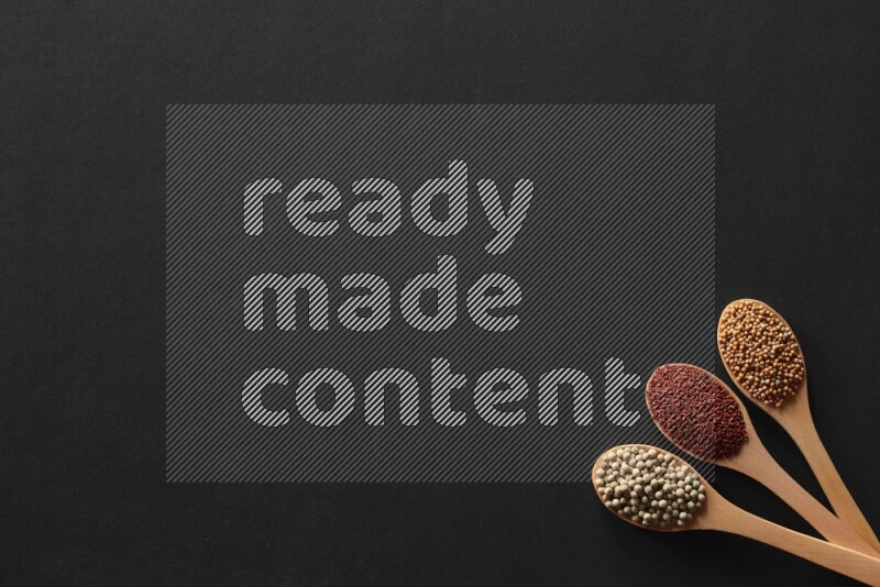 الفلفل الأسود وحبوب الخردل وحبة البركة وحب الرشاد والكمون و حبوب الكتان في معالق خشبية علي خلفية سوداء