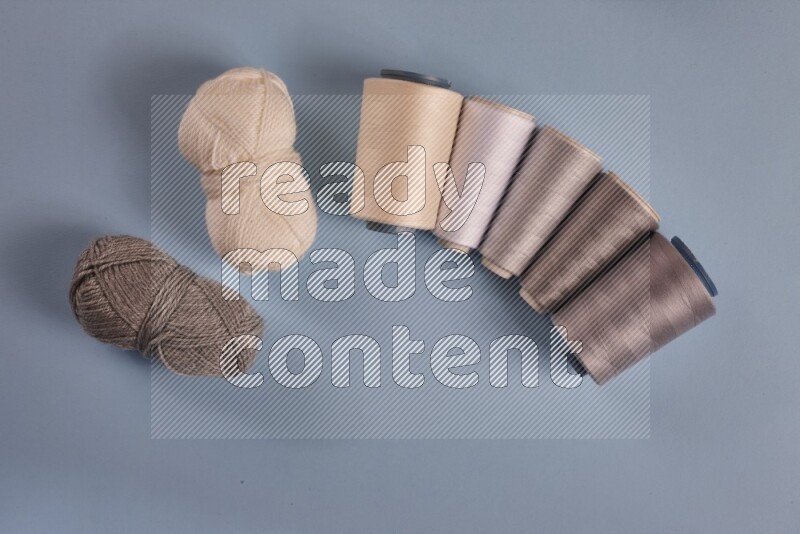 A grey collection of sewing and tailoring tools arranged on a blue background