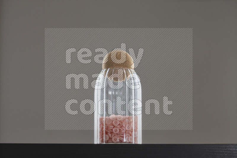Buttons in a glass jar on black background